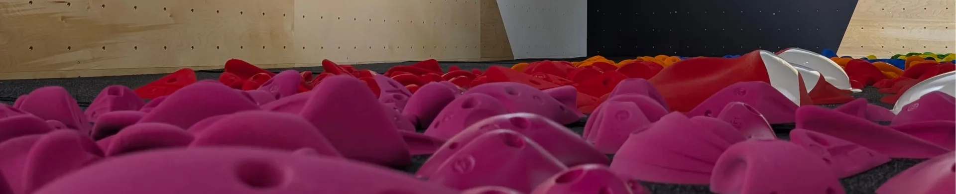 Presas de escalada rosas en la colchoneta